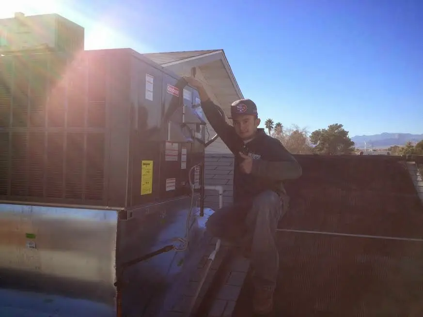 HVAC technician performing Boiler Repair on a rooftop unit in Nitro